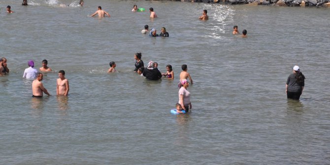 Sıcaktan bunalan kadın, çocuk, erkek elbiseleriyle göle atladı