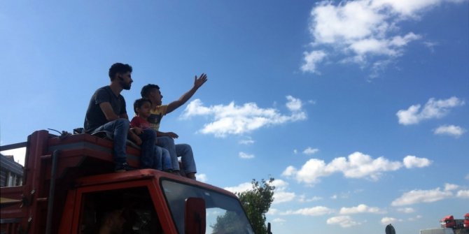 Yanlarındaki küçük çocukla kamyon tepesinde kurbanlık almaya gittiler