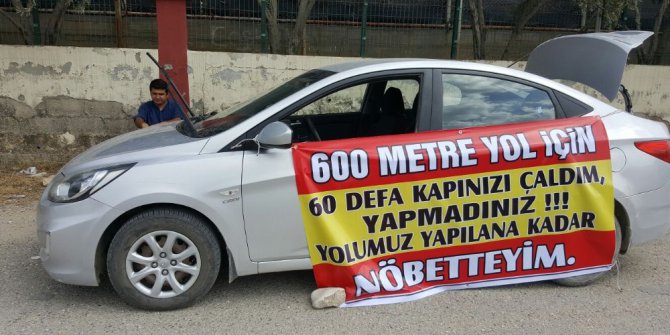 Köy muhtarından köy hizmetleri binası karşısında tek kişilik pankartlı eylem