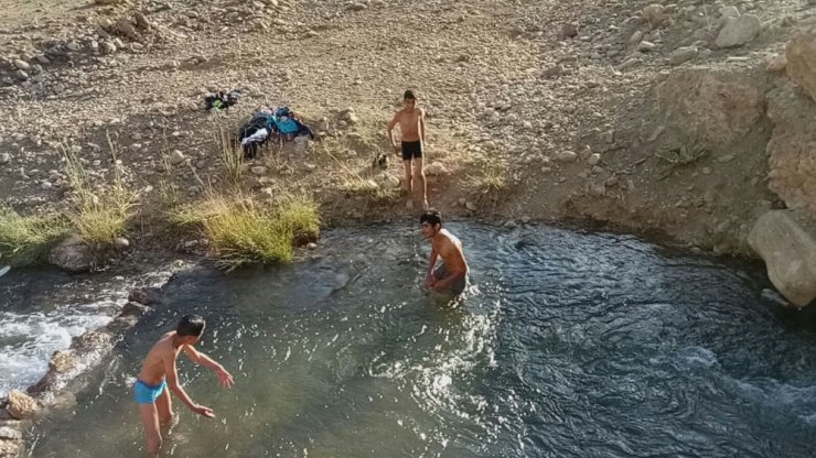 Sıcaktan bunalan çocuklar derede serinliyor