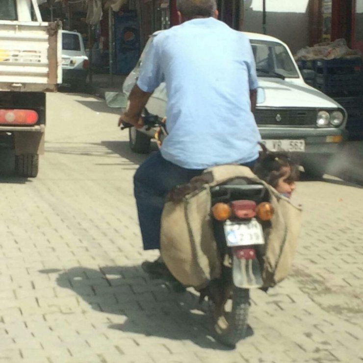 İki çocuğu motosikletin heybesinde götürdü