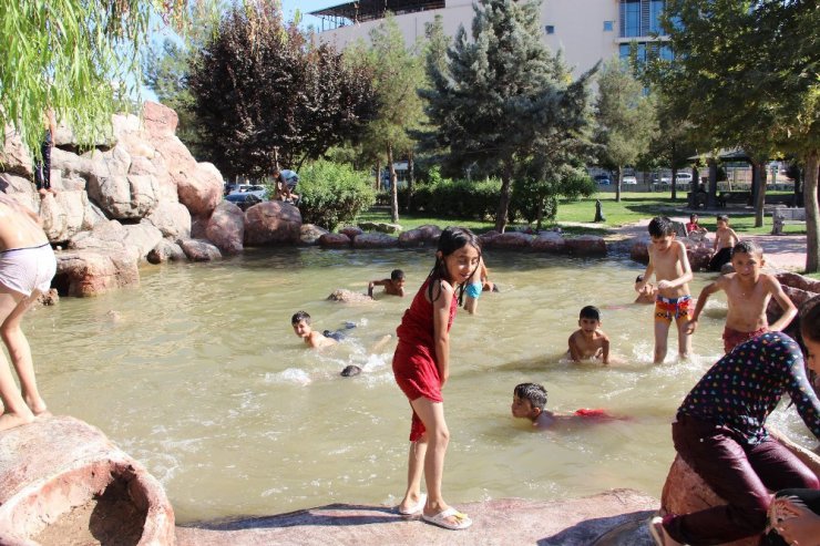 Çocuklar süs havuzunda serinliyor